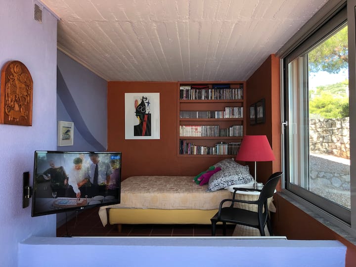El dormitorio con una cama individual que se comunica con el estudio.