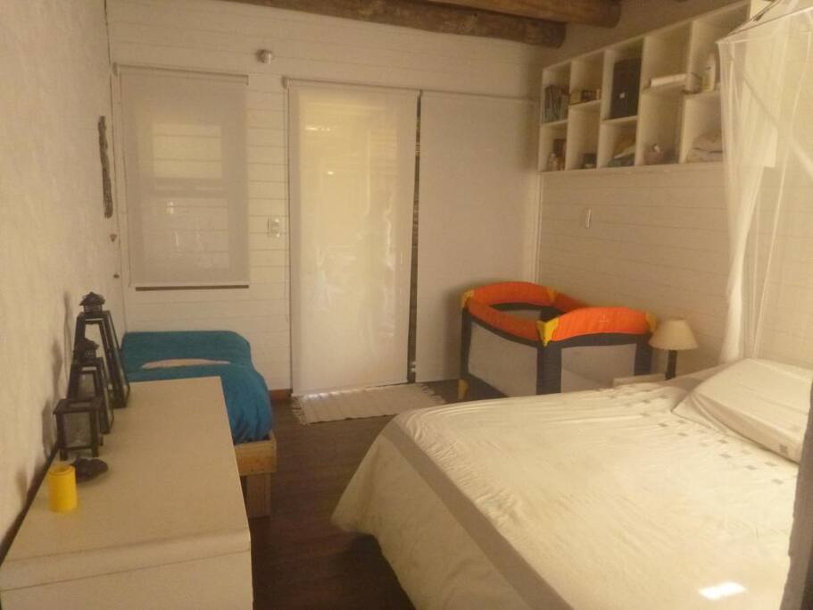 Cama matrimonial y cama simple en dormitorio en suite