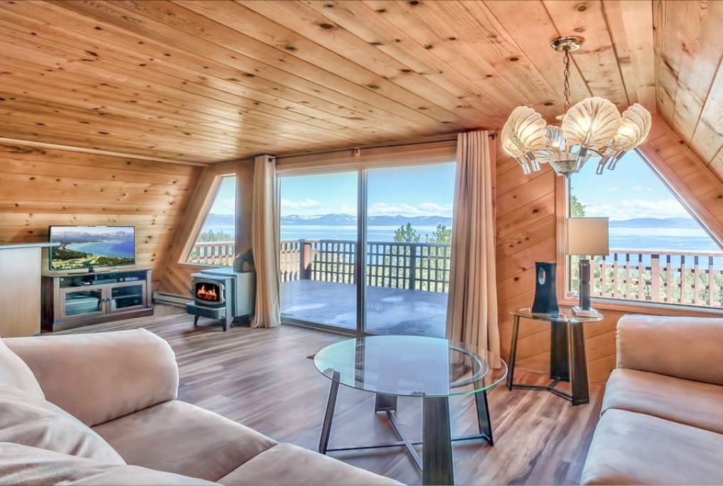 The living room features scenic panoramic lake views from the spacious sectional sofa.