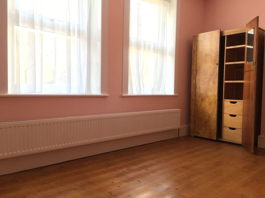 Bedroom 1 available, front-facing, finished wood floor.