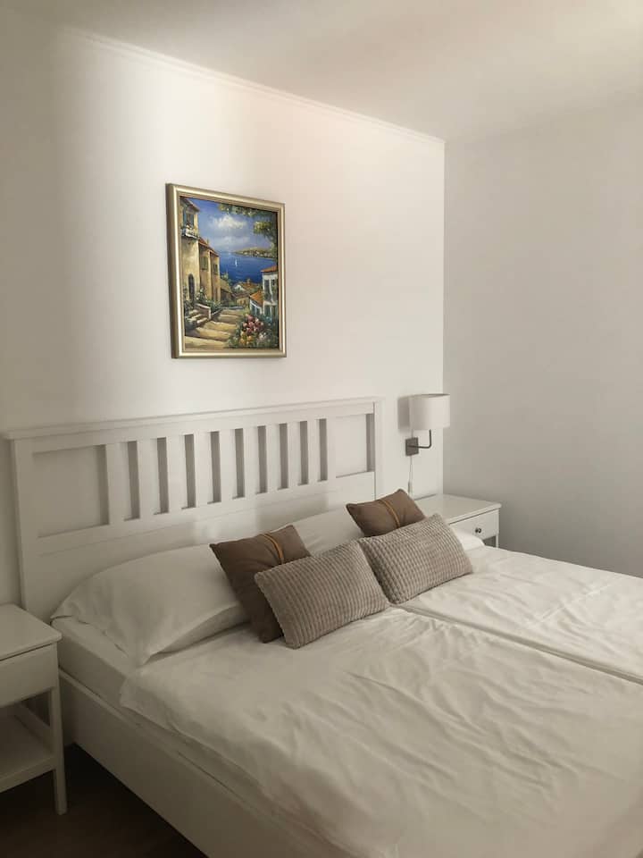 Segundo dormitorio del departamento "Iris" con cama tamaño king.