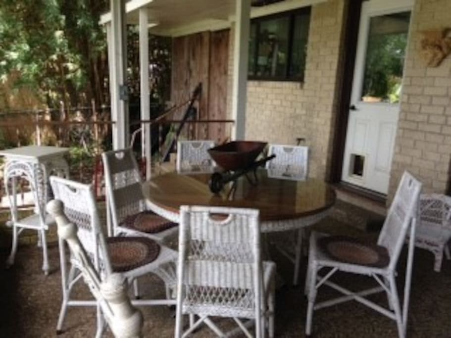 Large back porch furnished with antique wicker.