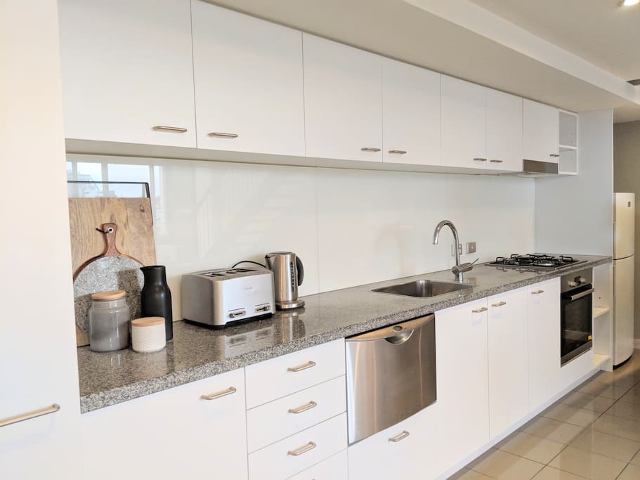 Fully equipped kitchen with 4 slice toaster, kettle, coffee machine, microwave, oven, cooktop, dishwasher and fridge.