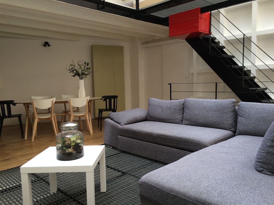 Le lumineux coin salon invite à la détente sous la verrière.