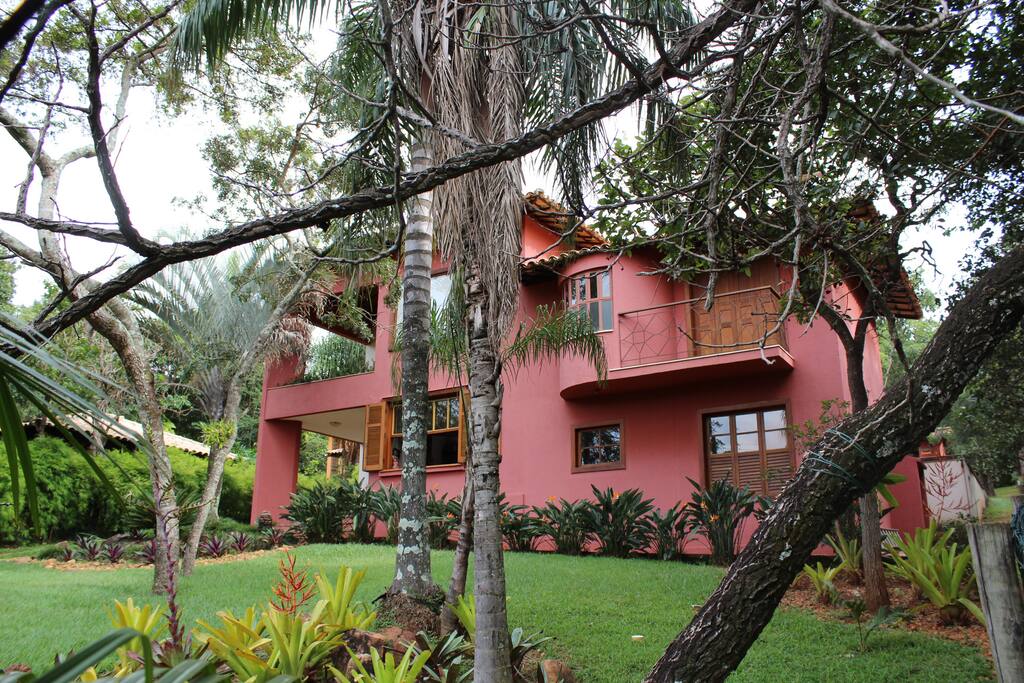 Vista frontal da casa, com dois andares e três varandas