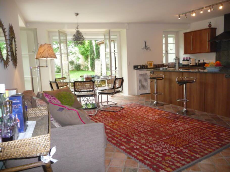 Open plan kitchen, dining room with sofa, TV and two sets of `French windows onto the garden