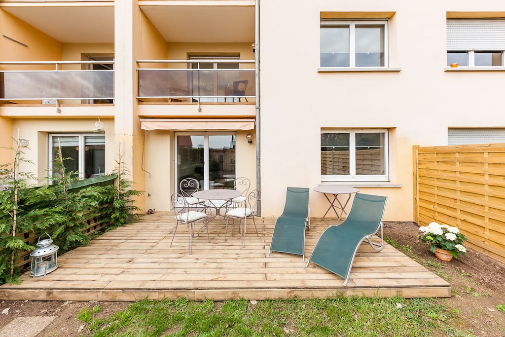 Une jolie terrasse en bois ensoleillée pour les repas à l'extérieur, et un coin détente