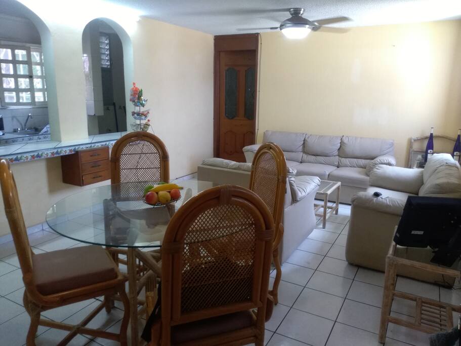 Sala con 3 sofás y 1 televisión con cable, 1 ventilador de techo.