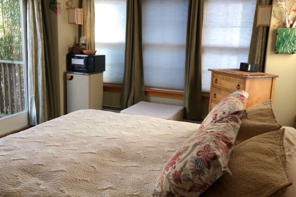 Queen bed with mini-fridge & microwave, chest of drawers with extra towels, & twin convertible ottoman.