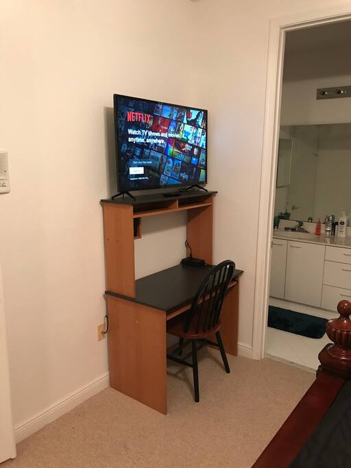 Desk and HD Smart TV inside room.