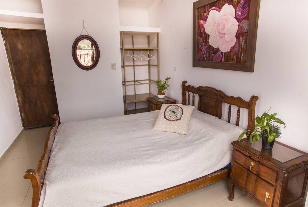 Dormitorio con cama matrimonial con salida a un balcón.