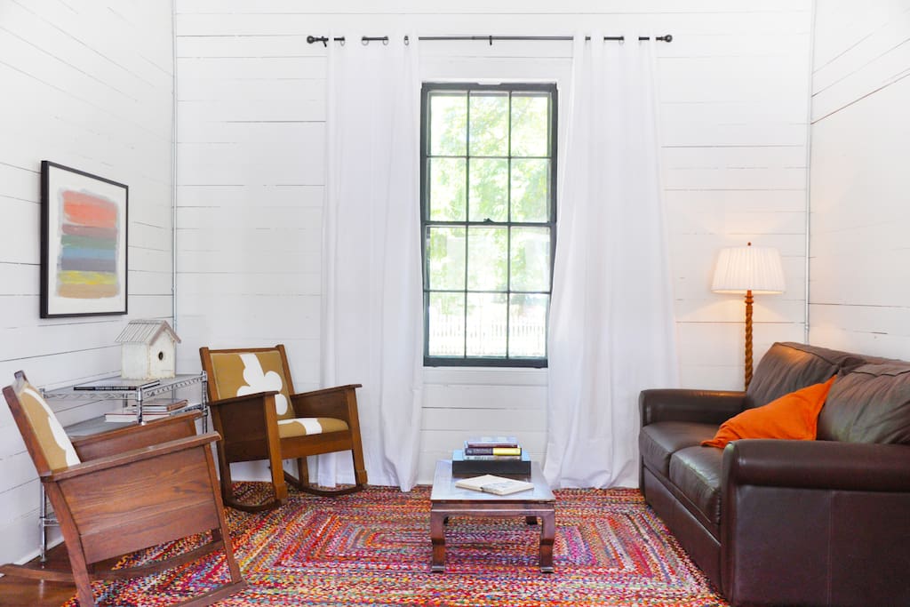 Living Room - 12 ft. ceilings with original shiplap walls and a queen sleeper sofa
