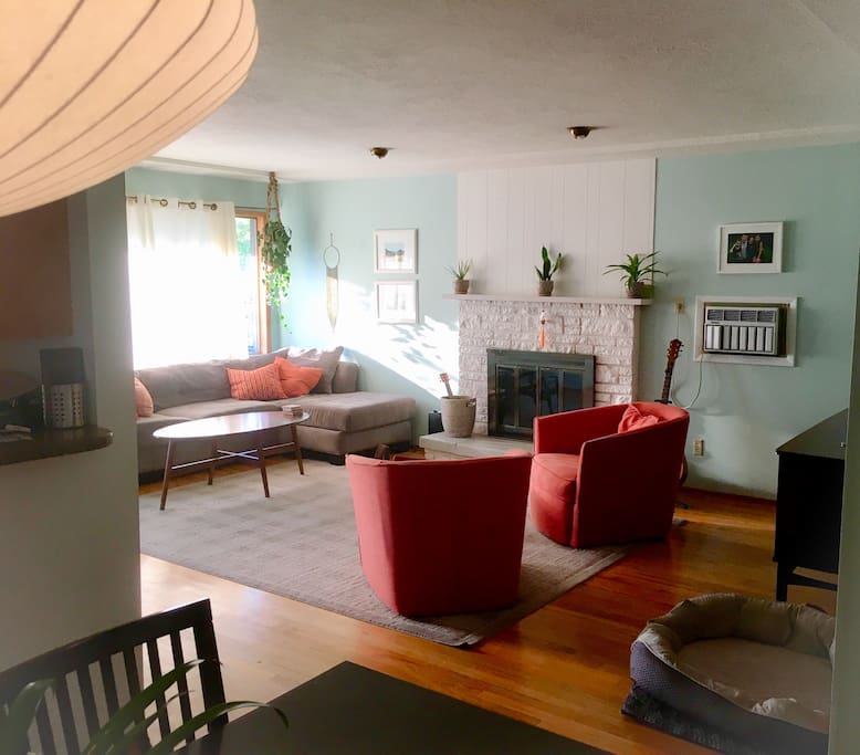 Living area is a great space for conversation or relaxation, with comfy couch, swivel chairs, large smart TV, wii, and air conditioner wall unit.