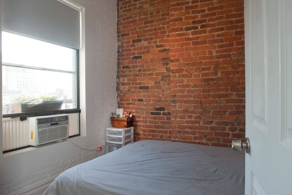 Guest room with exposed brick and sweeping city skyline views.