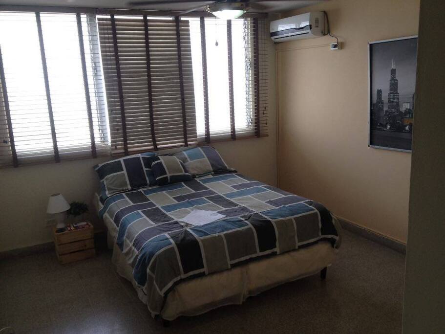 Your spacious bedroom with a/c and a queen size bed.