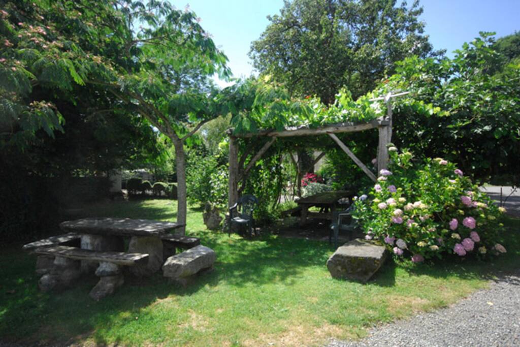 La pergola et table en pierre pour déjeuner au soleil