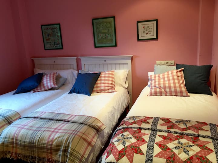 Habitación rosa con dos camas y una litera. Caben hasta 4 personas. Armario súper amplio para todos.