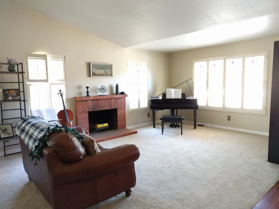 Spacious living room with an electric "grand" piano. Again, we have added a rocking chair for more seating.