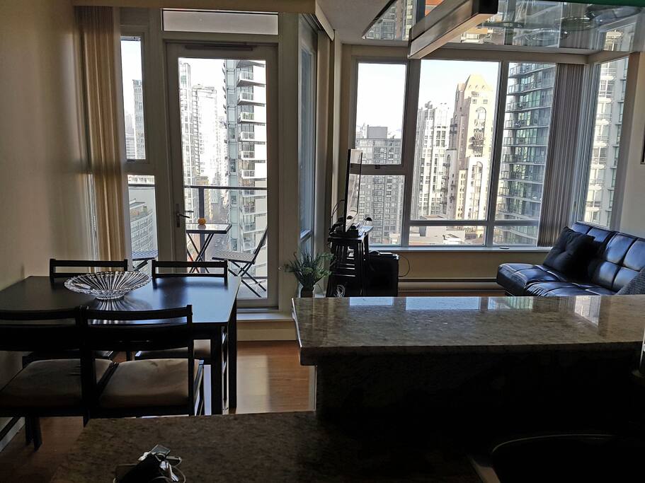 Cozy living room with a dining table, futon couch, 3D TV and balcony with bistro set