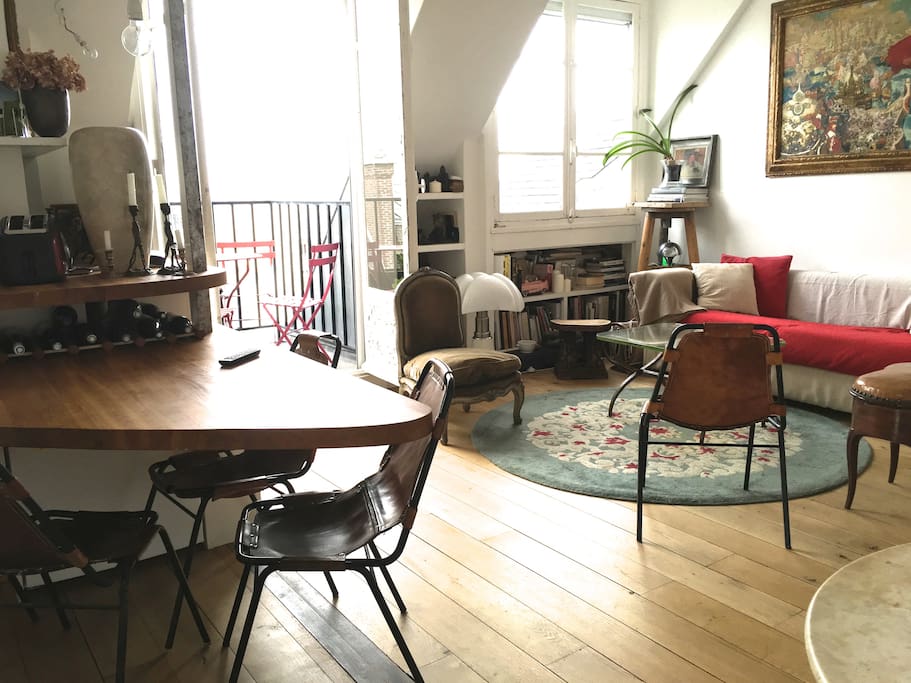 Séjour salle à manger de plain pied sur le balcon avec table chaises et vue tour Eifel