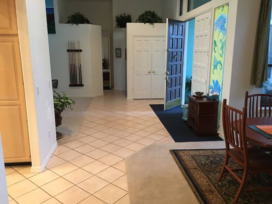 Front entrance view looking (in the distance) to Master Bedroom suite (straight), pool bathroom (left), billiard room (left), kitchen (left), home office (far right), front doors (right) and dining room (near right).
.