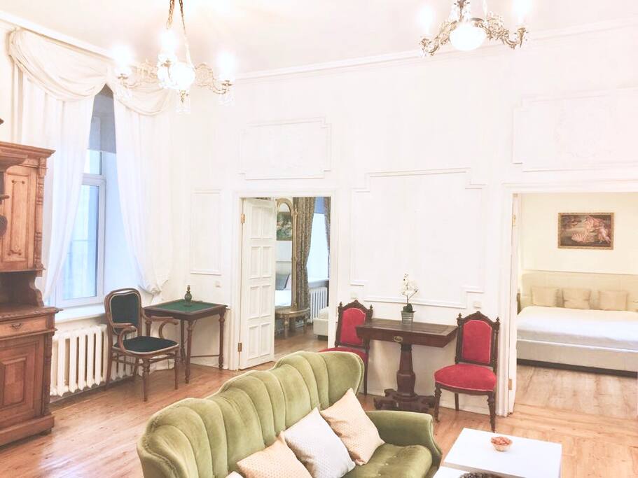 Spacious seating room with antique furniture and chandeliers.