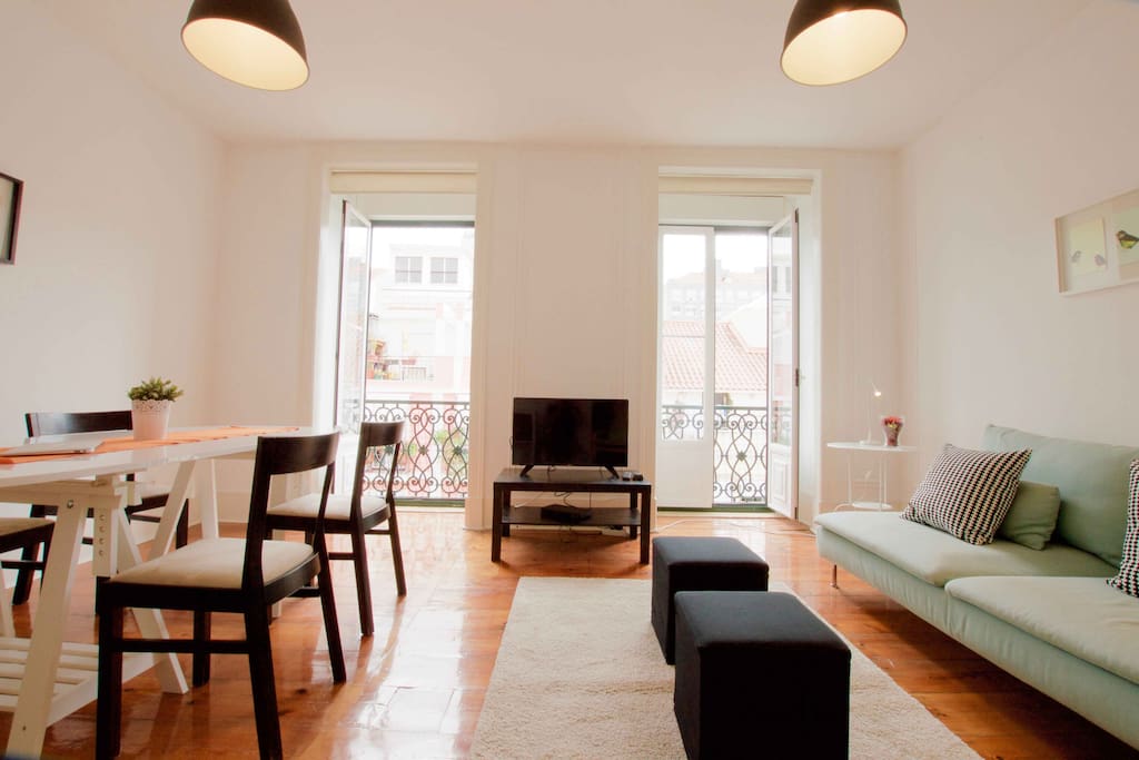 View of spacious living and dining area with plenty of natural light. High ceilings and long wood floors, typical of Lisbon architecture.