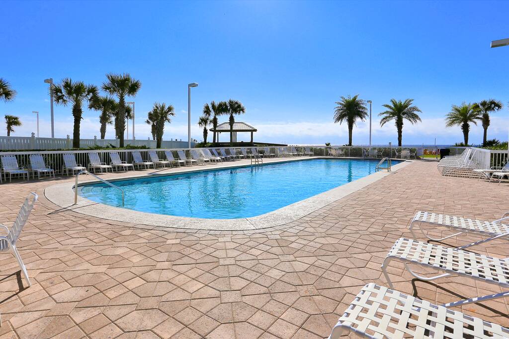 Tall palm trees border the shared pool.