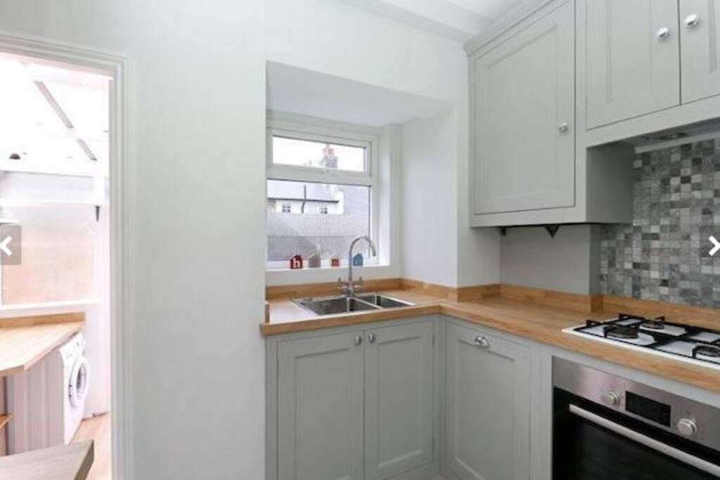 Kitchen leading out to utility area with washing machine