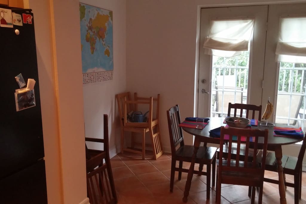 There is a table with extra chairs available inside. You look out to the patio.