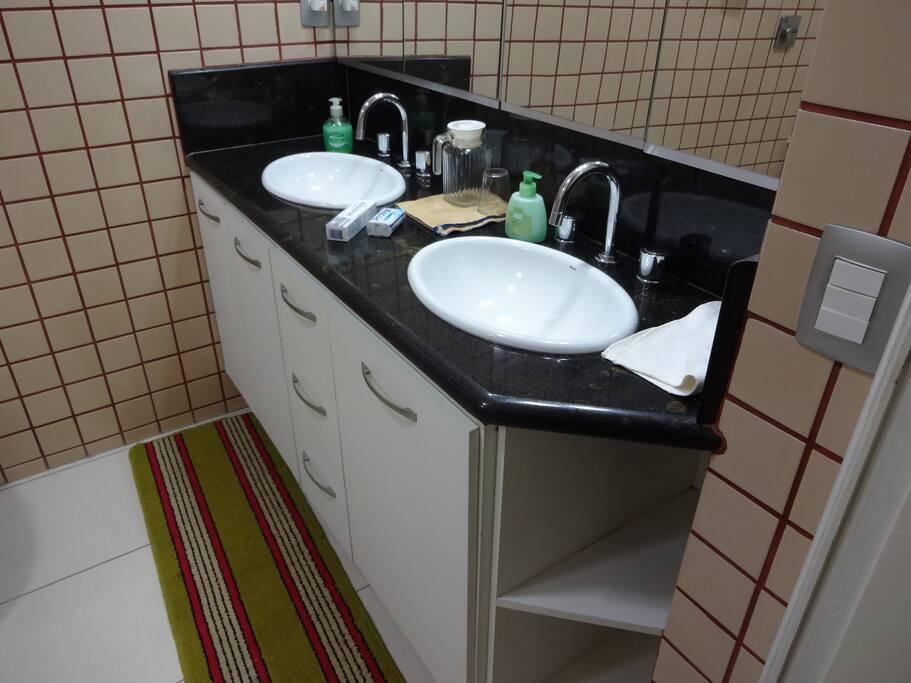 Banheiro suite com ducha e bancada água quente e fria.