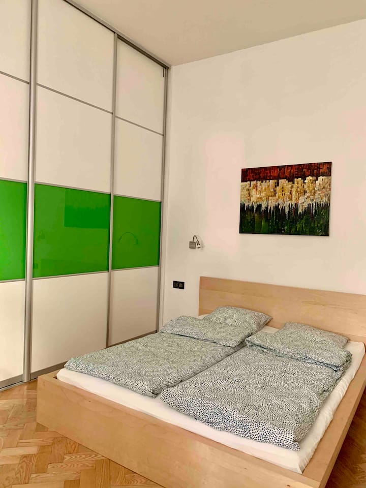 Cama tamaño king en un dormitorio y un armario empotrado