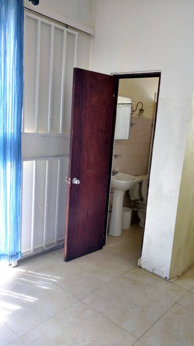 Bathroom door (with partial view of entrance glass door (and security metal sliding door))
