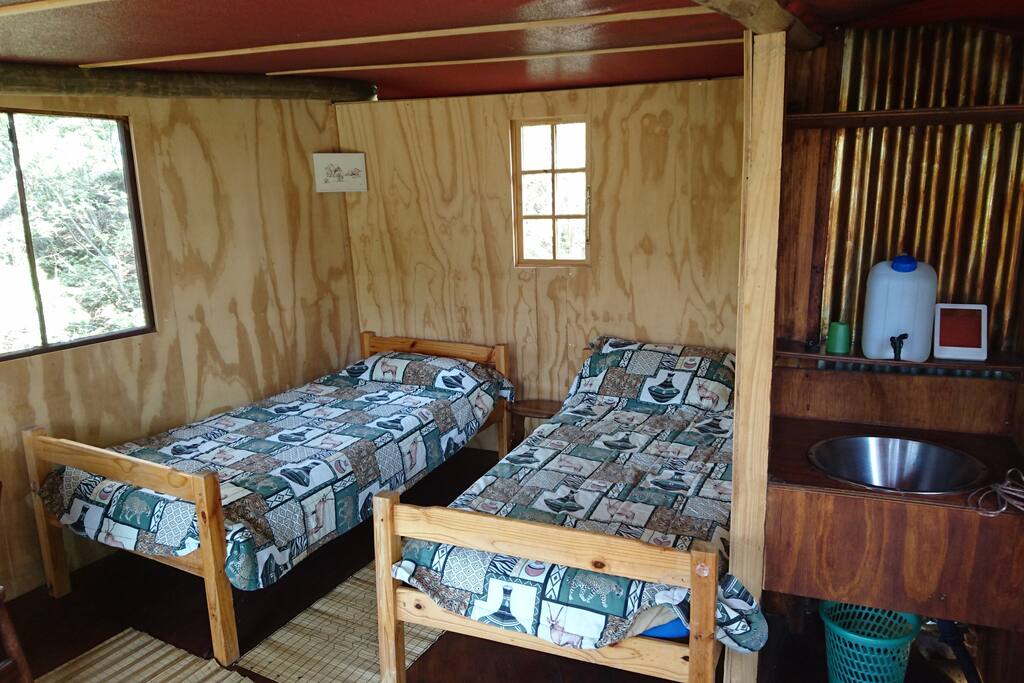 Two beds with a wash basin area
