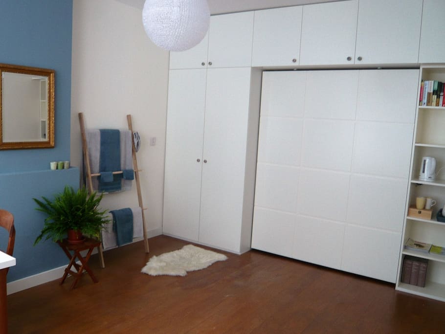 Grote, houten wandkast met veel opbergplekken en ruimte om het bed in te klappen.