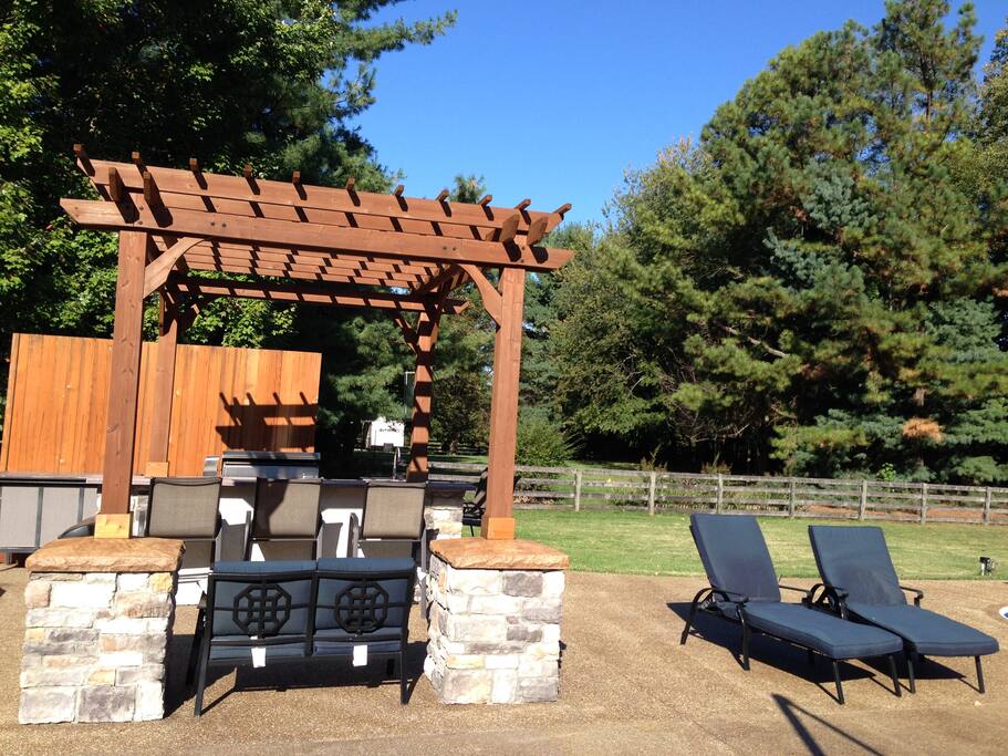 Outdoor kitchen with sink, refrigerator, cabinets and DCS grill.