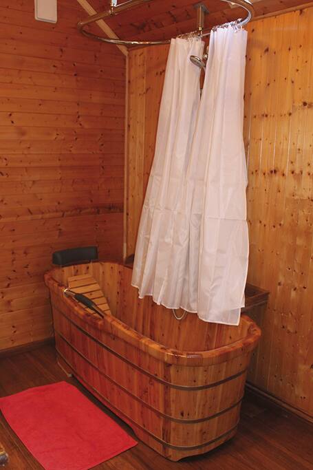 La baignoire en bois (hévéa) de la salle de bain de la chambre Framboises...