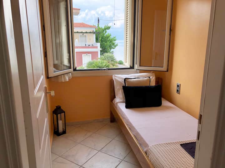 de slaapkamer met een eenpersoonsbed en uitzicht op de zee