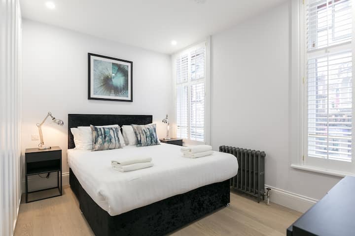 Priestranná spálňa s elegantným interiérom doplnená rozsiahlymi úložnými riešeniami. 