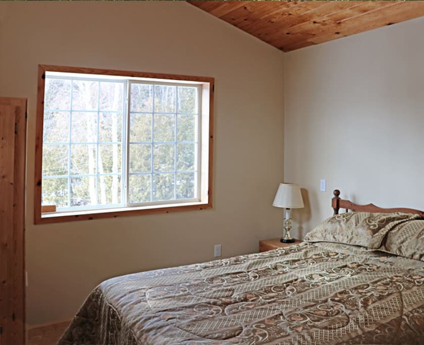 Garden view guest bedroom with private entrance and shared bathroom on main floor