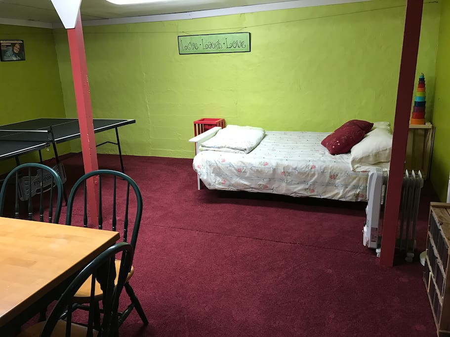 This is the basement guest room and rec room. The bed is a full size futon couch/bed. There's a ping pong table and a dining table.