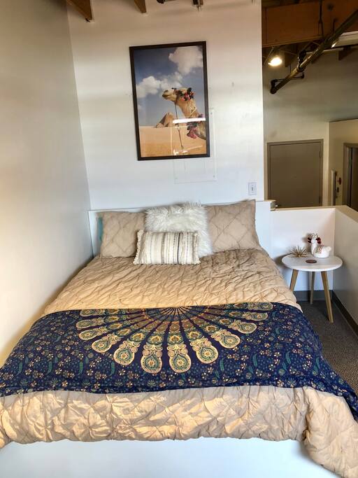 Queen sized bed with side table and plugs for charging devices