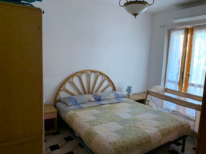 Спална соба со двоен кревет и бебешко креветче што може да се отстрани