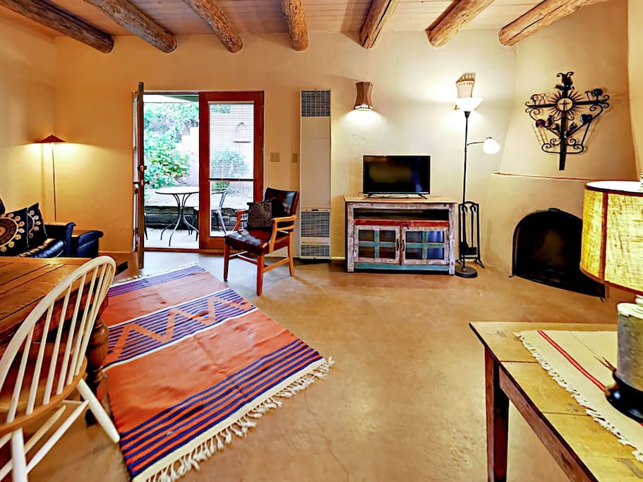 With a kiva wood-burning fireplace and exposed beams, the main living area embodies classic Santa Fe charm.