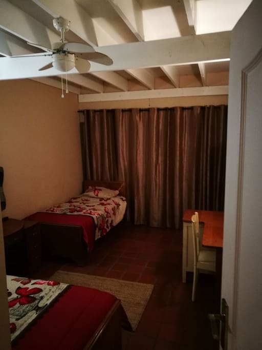 Downstairs bedroom with 2 single beds. Sliding doors lead out to patio.