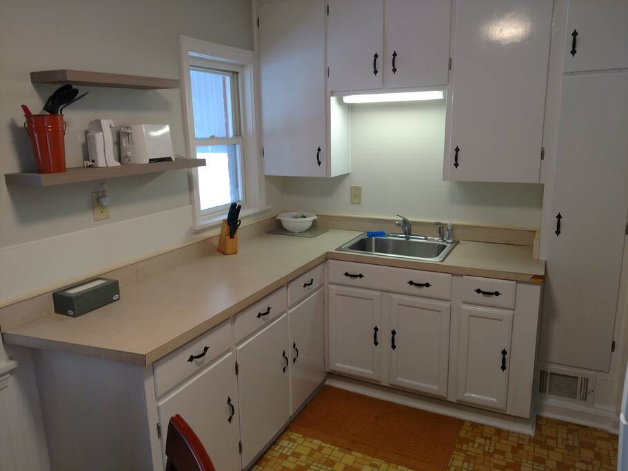 Efficient kitchen with dishes, silverware, utensils, pots, pans and baking sheets as well as most small kitchen appliances and basic spices.