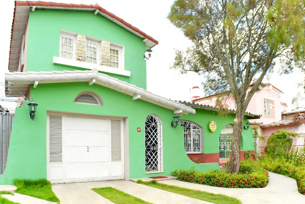 Frente de la casa con parqueo interior.