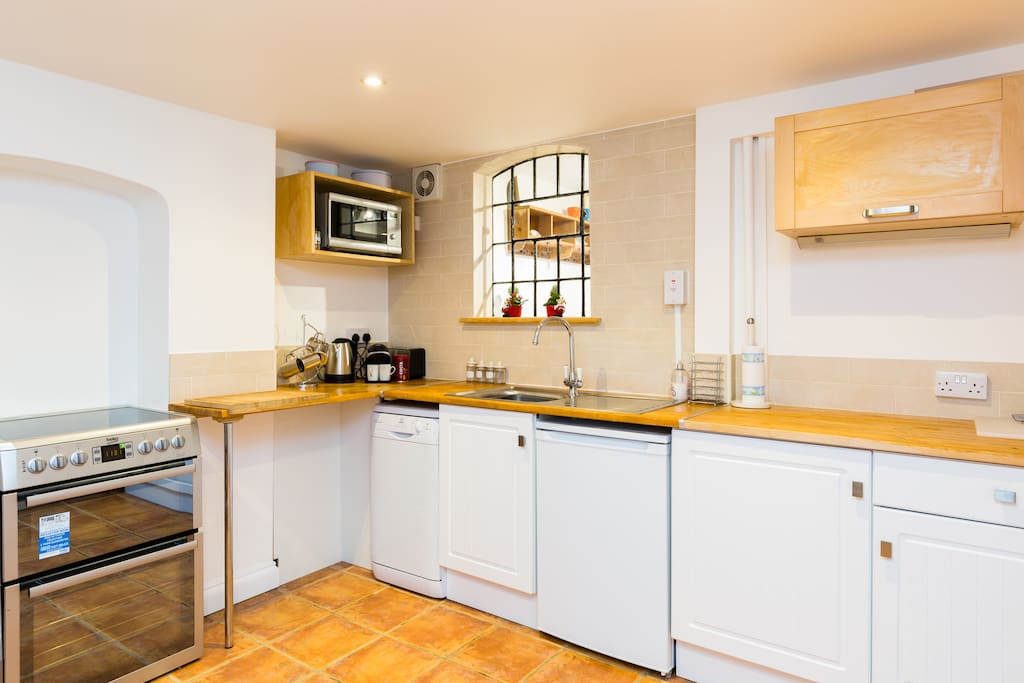 Kitchen with dishwasher, fridge, fan assisted oven, table and chairs.