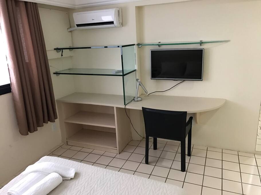 Mesa de trabalho e televisão na suíte