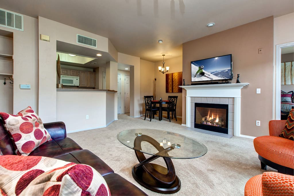 Wide living area with fireplace and flatscreen TV.